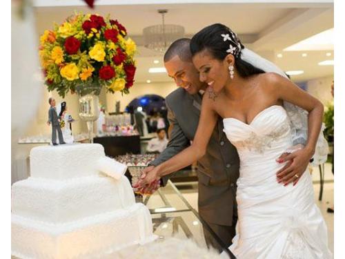 O corte do bolo simbolizando o primeiro ato de partilha do casal